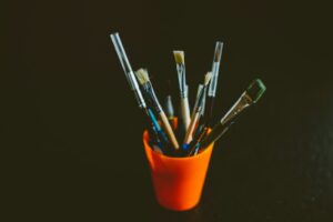 assorted paint brush set on orange plastic container